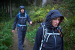 Young hiking couple hiking through forest in hooded anoraks in rain, Manigod, Rhone-Alpes, France