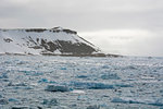 Frozen landscape and distant snow capped mountain, Wahlenberg Fjord, Nordaustlandet, Svalbard, Norway