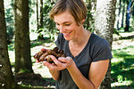 Woman with handful of pine cones in forest, Sonthofen, Bayern, Germany