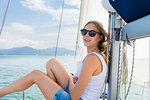 Young woman wearing sunglasses on sailboat on Chiemsee lake, portrait, Bavaria, Germany