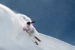 Male skier skiing down steep mountainside, Alpe-d'Huez, Rhone-Alpes, France