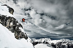 Male skier  jumping mid air from rugged mountainside, Alpe-d'Huez, Rhone-Alpes, France