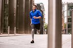 Young runner jogging in city square, London, UK