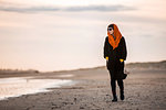 Woman walking alone on beach