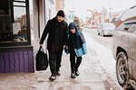 Father and son walking past shop in winter