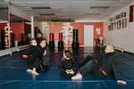 Coaches and students resting in martial arts studio