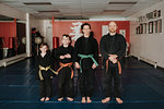 Coaches and students posing in martial arts studio