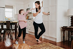 Girl extending hand to mother in kitchen