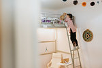 Girl playing with cat on loft bed