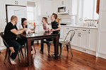 Family of four playing cards in kitchen