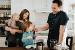 Mid adult couple with toddler daughter and baby son at kitchen table