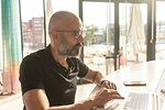 Man using laptop in office on sunny day