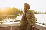 Indian man exploring city, river in background, Berlin, Germany