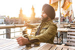 Indian man exploring city, river in background, Berlin, Germany