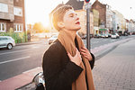 Woman on sidewalk with eyes closed, Cologne, Nordrhein-Westfalen, Germany