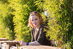 Young woman relaxing in cafe by river in summer