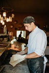 Chef preparing pizza dough in open kitchen