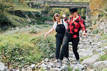 Women walking in dry riverbed, Rezzago, Lombardy, Italy