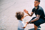 Father and son playing with confetti in park