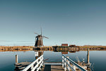 View of windmill along canal from pier, Kinderdijk, Zuid-Holland, Netherlands