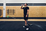 Man with prosthetic leg drinking water in gym