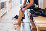 Man with prosthetic leg in gym changing room