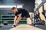 Man with prosthetic leg stretching in gym