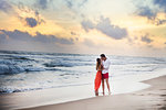 Young couple kissing on beach at sunset, Hikkaduwa, Southern, Sri Lanka