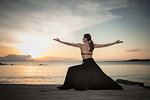 Woman practising yoga at seaside