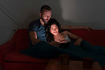 Hipster couple using digital tablet on sofa