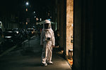 Astronaut walking on pavement at night