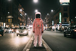 Astronaut in middle of busy street at night