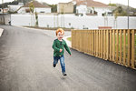 Boy running on road in residential area