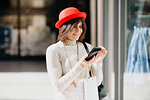 Female shopper using smartphone in front of shop