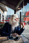 Senior businessman looking out of window in cafe, Milano, Lombardia, Italy