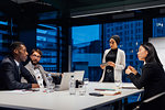 Businesswomen and men having discussion during office presentation