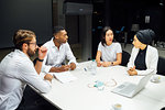 Businessmen and women having discussion during conference table meeting