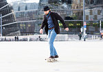 Man skateboarding in city square, Freiburg, Baden-Wurttemberg, Germany
