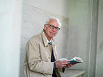 Senior man in raincoat reading newspaper, portrait, Copenhagen, Hovedstaden, Denmark