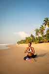 Woman practising yoga on beach