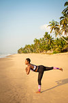 Woman practising yoga on beach