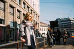 Young woman looking at smartphone at tram station