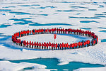 People wearing red forming circle around North Pole, Arctic