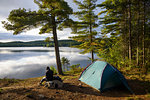 Hiker camping by Provoking Lake in Algonquin Provincial Park, Ontario, Canada, North America
