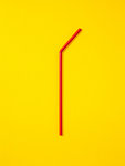 Red straw laid vertically on yellow background