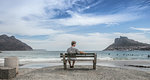 Mature man sitting looking out from beach bench, Cape Town, Western Cape, South Africa