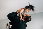 Girl being held up by father, side view