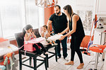 Mid adult couple in kitchen with daughter and baby son in high chairs