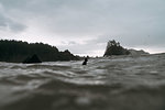 Young male surfer in cold pacific ocean, surface level view, Arcata, California, United States