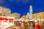 View of Christmas Markets stalls and St. Michael Catholic Church in Michaelerplatz at dusk, Vienna, Austria, Europe